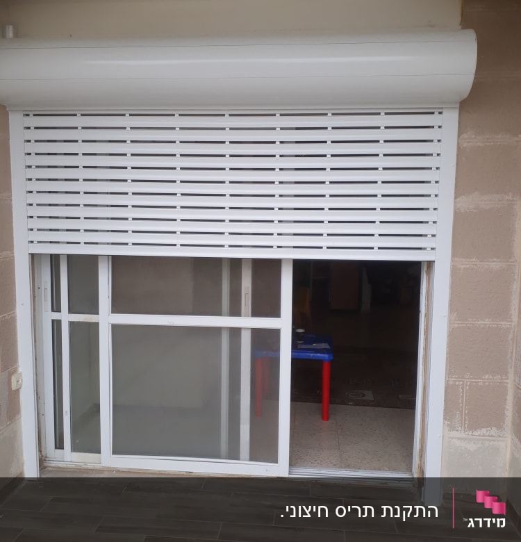 תריס אלומיניום לבן חצי פתוח על חלון זכוכית